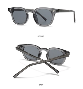 Detail of retro grey sunglasses featuring metal wing accents and cross motifs on the arms