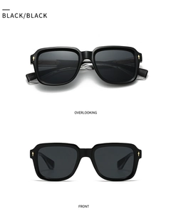 Detail of black square sunglasses featuring iconic golden diamond metal rivets on frames