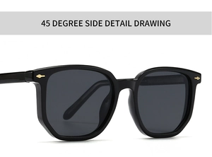 Close-up of black oversized sunglasses with golden metal arrow detail on 45 degree side
