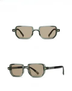 Details einer grünen quadratischen Sonnenbrille mit Teegläsern und goldenen Metallscharnieren
