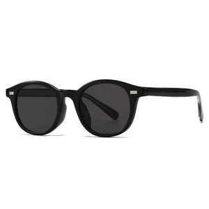 Retro round frame sunglasses in glossy black resin with metallic rivets and dark lenses