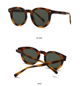 Detail view of tortoiseshell sunglasses with dark green lenses and metal rivets