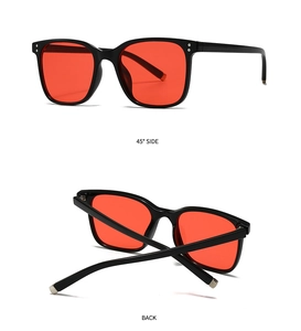 Detail views of black square sunglasses with metallic rivets and bright red lenses