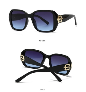 Detail of square black sunglasses with blue gradient lenses and gold metal logo temple