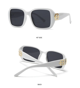 Detailed macro view of white square sunglasses with gold metal logo and black lenses