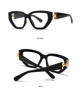 Detail of luxury black square sunglasses featuring gold H-shaped metal hinges and frame