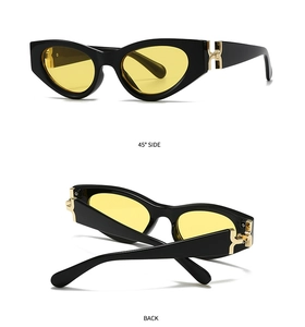 Détail de lunettes de soleil carrées avec monture noire et charnière en H dorée