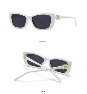 Detailed view of white cat-eye sunglasses with golden G-logo hinge and dark lenses