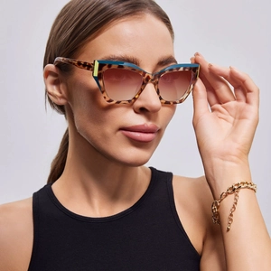 Detailed close-up of tortoise shell cat-eye sunglasses with yellow and blue accents