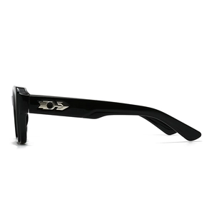 Close-up of black sunglasses featuring a signature silver arrow hinge on the temple arm