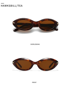 Macro detail of tortoiseshell oval sunglasses with gold T-shaped metal hinges and tea lenses