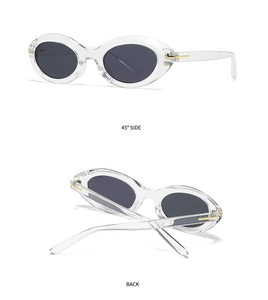 Detail view of transparent oval sunglasses with golden T-metal hinge and grey lenses