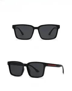 Detail view of square black polarized sunglasses featuring a red rectangle temple accent