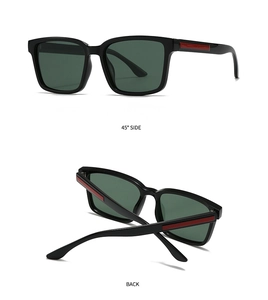 Detail view of square black sunglasses with dark green lenses and red temple accents