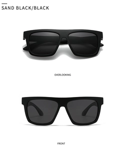 Detail view of square sand black sunglasses with thick frames and black lenses