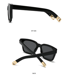 Detail view of black square sunglasses with wide temples and golden metal ornaments