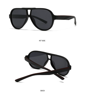 Detail view of round black oversized sunglasses featuring a double bridge and red temple accents
