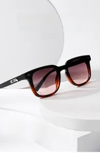 Gros plan de lunettes de soleil carrées noires avec détails écaille de tortue aux tempes