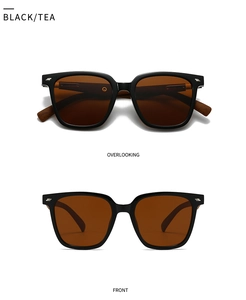 Close-up of retro square black frames with silver rivets and tea-colored lenses