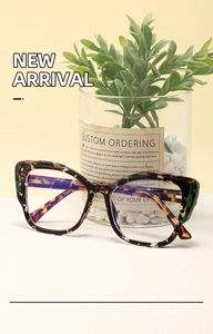 Detail of tortoise shell cat-eye glasses with anti-blue light lenses on a clean desk