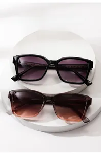 Detail of square oversized sunglasses in black and transparent tea colors with gradient lenses
