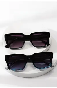 Detail of square frame sunglasses with dark purple lenses and stylish tortoiseshell pattern