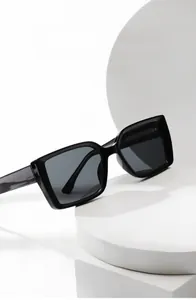 Detail of black rectangular sunglasses on white geometric display stand with UV lens
