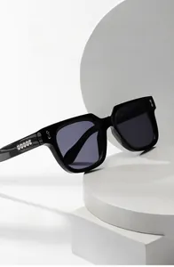 Detail einer quadratischen schwarzen Sonnenbrille mit silberner Kette an den Bügeln und UV-Schutz