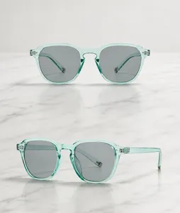 Detailweergave van de retro zonnebril met vierkante dubbele brug en groen transparant frame
