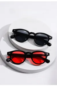 Detail of retro round sunglasses with black and red lenses on white pedestals