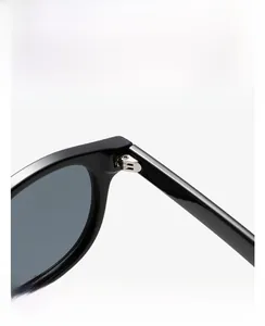 Detailed macro view of the silver metal hinge on vintage round black sunglasses frame