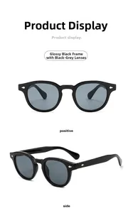 Detail view of round black sunglasses with silver diamond rivets and dark grey lenses