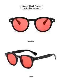 Detail view of retro round sunglasses with bright black frames and red tinted lenses