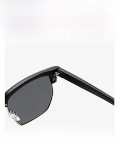Détails des charnières robustes et du bord en métal argenté sur lunettes de soleil noires