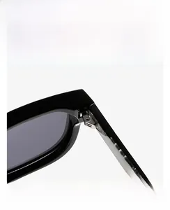 Macro view of a silver metal hinge connecting a glossy black square frame and temple