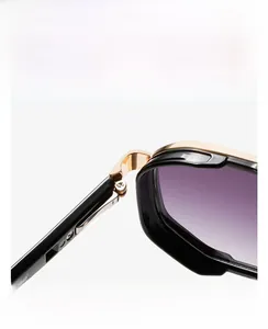 Detail of gold metal hinge and purple gradient lens on retro black sunglasses