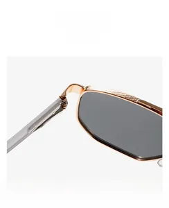 Macro detail of gold metal frame with textured mesh engraving and grey lenses