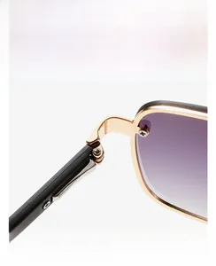 Detail view of gold metal hinge and purple gradient lens on retro narrow sunglasses