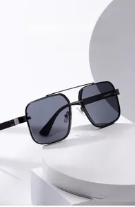 Detail of black square sunglasses featuring red and green striped accents on the temple
