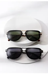 Detail of retro narrow frame sunglasses featuring metal bridge and stud accents