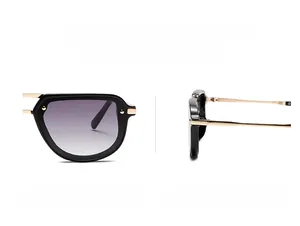 Detail of narrow retro sunglasses with black frames, gold metal temples and gradient lenses
