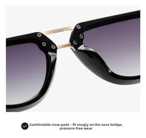 Close-up of golden metal bridge and ergonomic nose pads on narrow black retro sunglasses