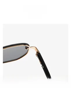 Detail shot of black sunglasses frame showing golden metal hinge and screw construction