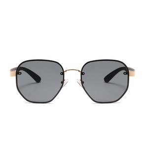 Modern narrow polygonal sunglasses with black lenses and gold bridge in a studio view