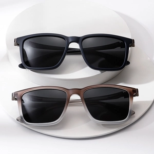 Classic square frame sunglasses in matte black and gradient grey on minimalist stone steps