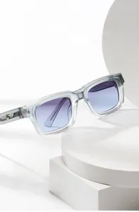 Detail der quadratischen Sonnenbrille mit grauem Rahmen und silbernen Flügelakzenten