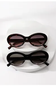 Detail of tortoise shell and black oval sunglasses on white steps with a refined finish