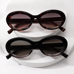 Retro oval sunglasses in tortoiseshell and black frames displayed on white podiums