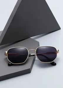 Detail of retro polygon metal sunglasses with gold frame and dark lenses on a pedestal