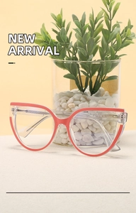 Detail view of cat-eye anti-blue light glasses with transparent frame and red accents